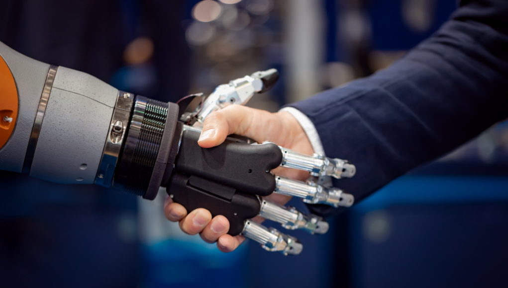 Hand of a businessman shaking hands with a Android robot.